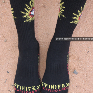 Front-on photo of black Spinifex Skate branded socks